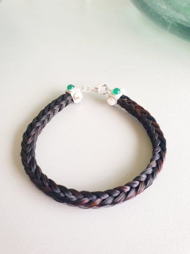 Pulsera de cuero trenzado con cuentas plateadas y verdes.